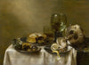 A still life with an overturned silver tazza, glassware, pies and a peeled lemon on a table