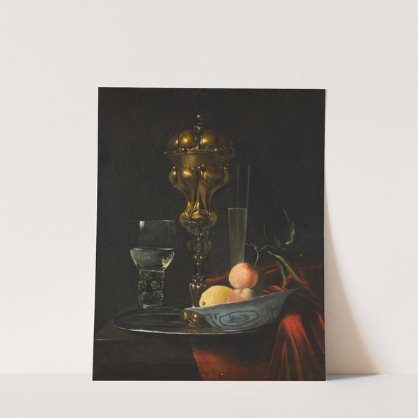 Still life with a gilt cup on a silver plate, a porcelain bowl with fruit, a roemer, and a wine glass, all on a wooden table draped in red fabric by Christiaen Striep