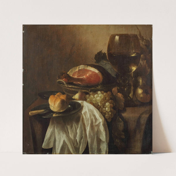 A pewter platter with a knife and bread roll, a wicker basket with a joint of ham, grapes and a pear, a roemer of wine on a partly-draped table by Cornelis Kruys