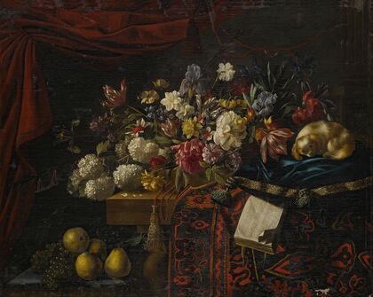 A still life of flowers set on a table with a carpet, a music book and a dog seated on a pillow