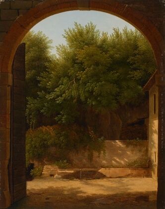 A view of a sunlit courtyard with a trough, seen through an archway