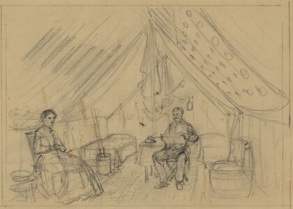 An officer and a woman sitting in a tent