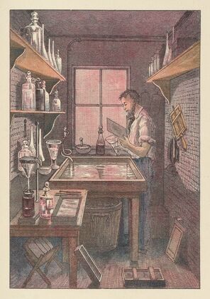 Photographer at work in a room lighted through a window of red glass