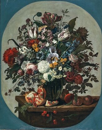 Tulips, squills hydrangeas, peonies, and other flowers in a vase surrounded by pomegranates and other fruit, on a stone ledge